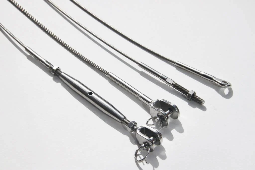 Metalen kabels en spanners met vork- en draadeinden op een witte ondergrond